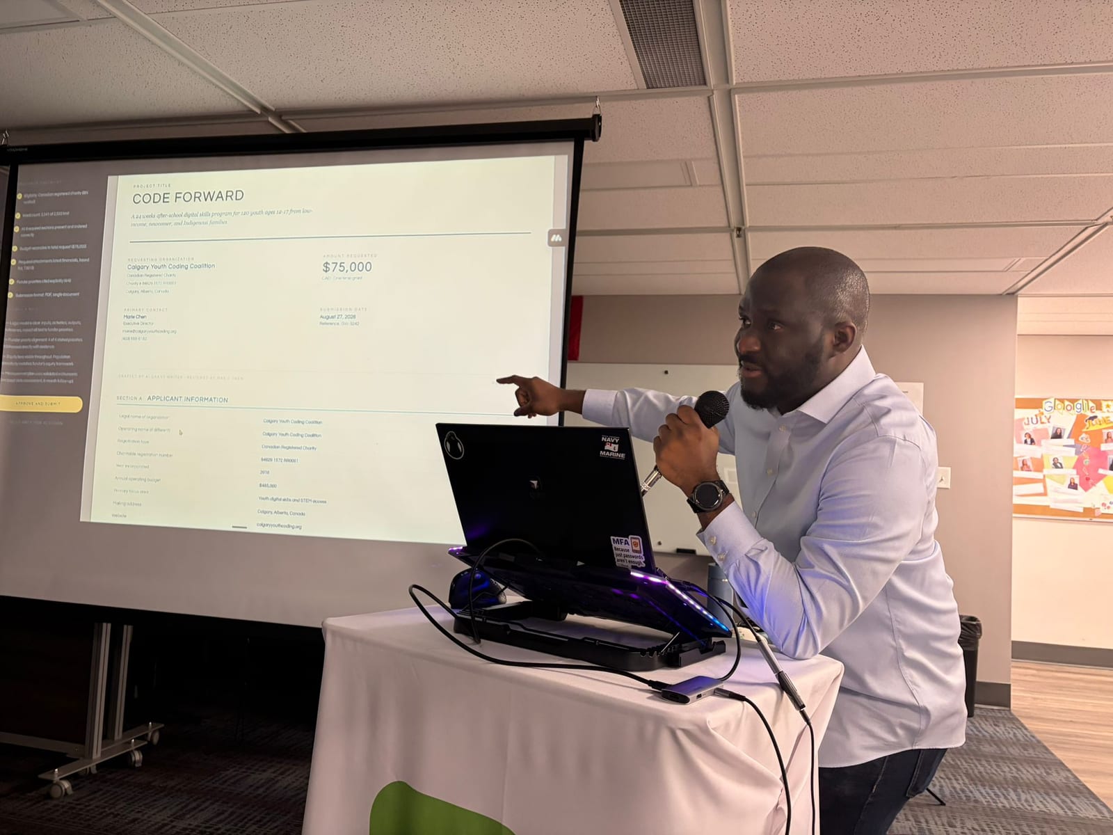 Ev Oputa speaking at the AI Systems for Nonprofit Operations workshop, pointing at a projected grant form